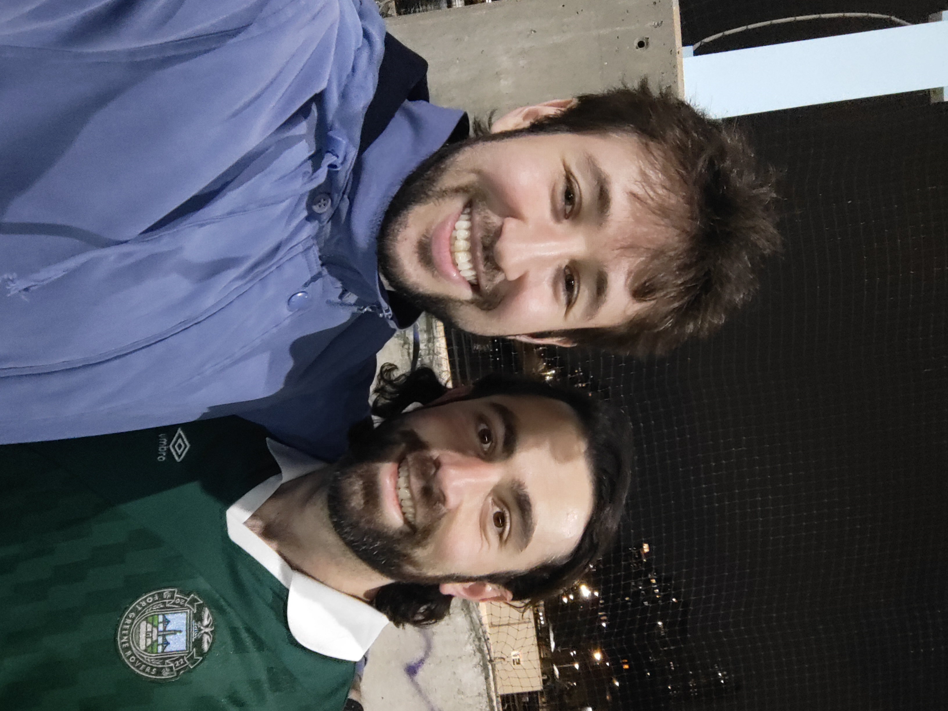Coach Sam, in a Fort Greene Rovers jersey, smiling with a teammate after a night game
